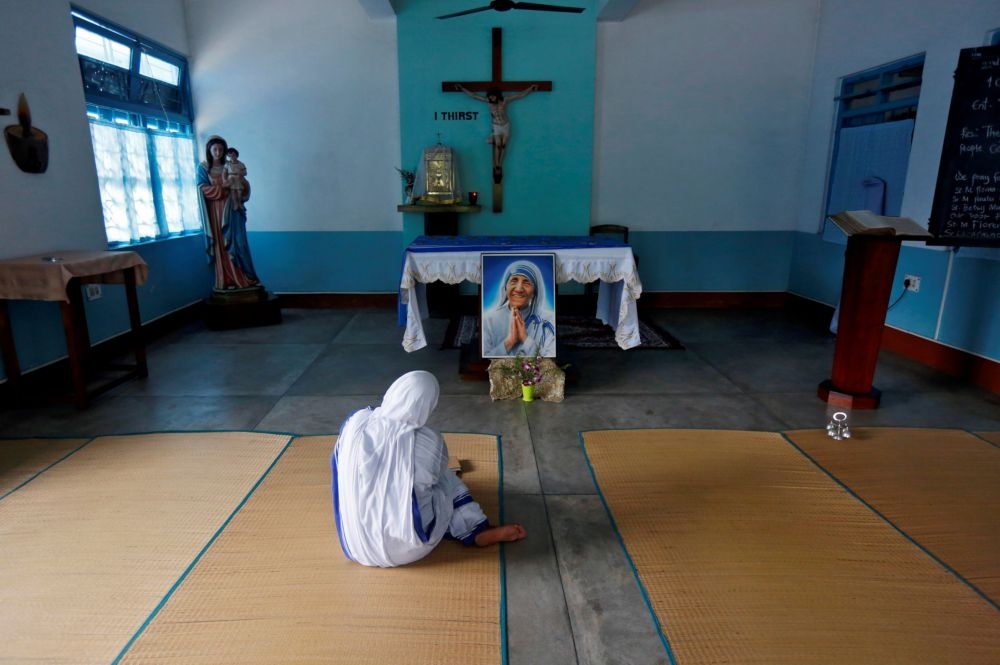 印度1名修女在泰瑞莎修女畫像前祝禱。（湯森路透）
