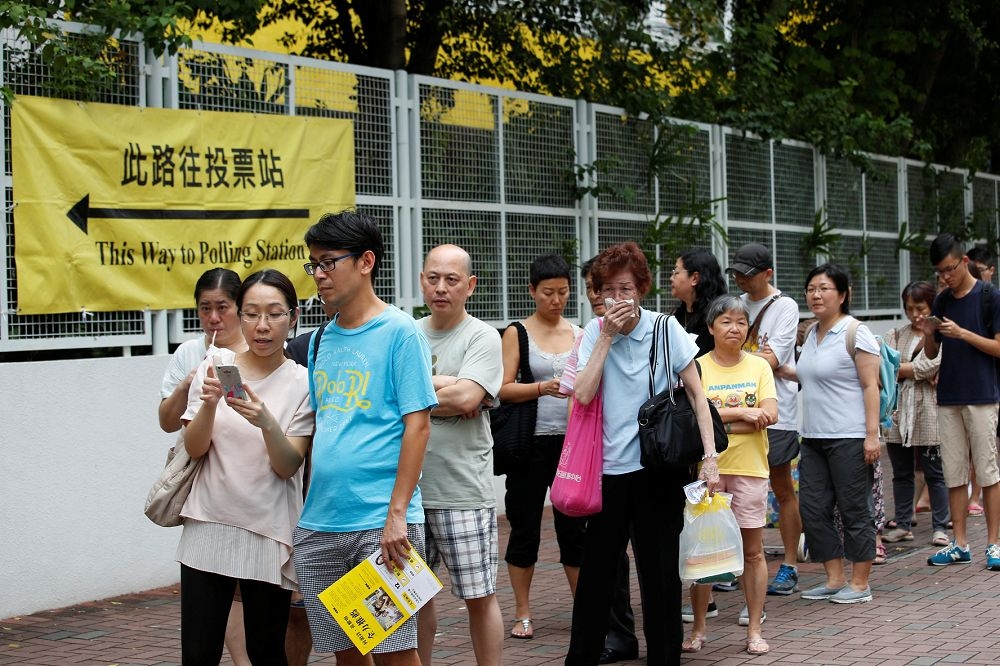 這次選舉是香港回歸以來，投票率最高一次，達58%，幾個投票所大排長龍等待投票，甚至有到晚上兩點半才投完的地區。（路透社）