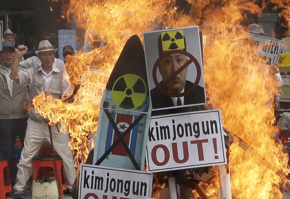南韓民眾不滿北韓一意孤行核試驗，10日在首爾街頭怒燒金正恩照片抗議。 （美聯社）