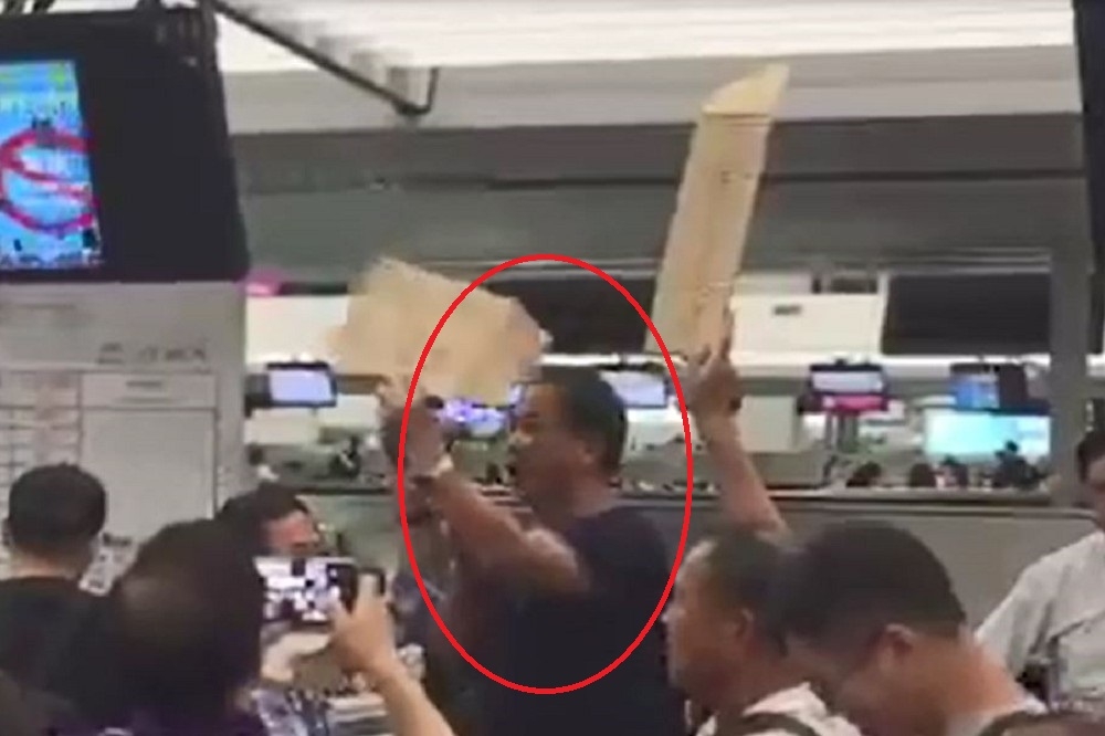 因不滿華航班機取消且並未安排食宿，國民黨籍屏東縣議員張榮志(紅圈)在香港機場拿著大聲公進行抗議。（翻攝自Youtube）