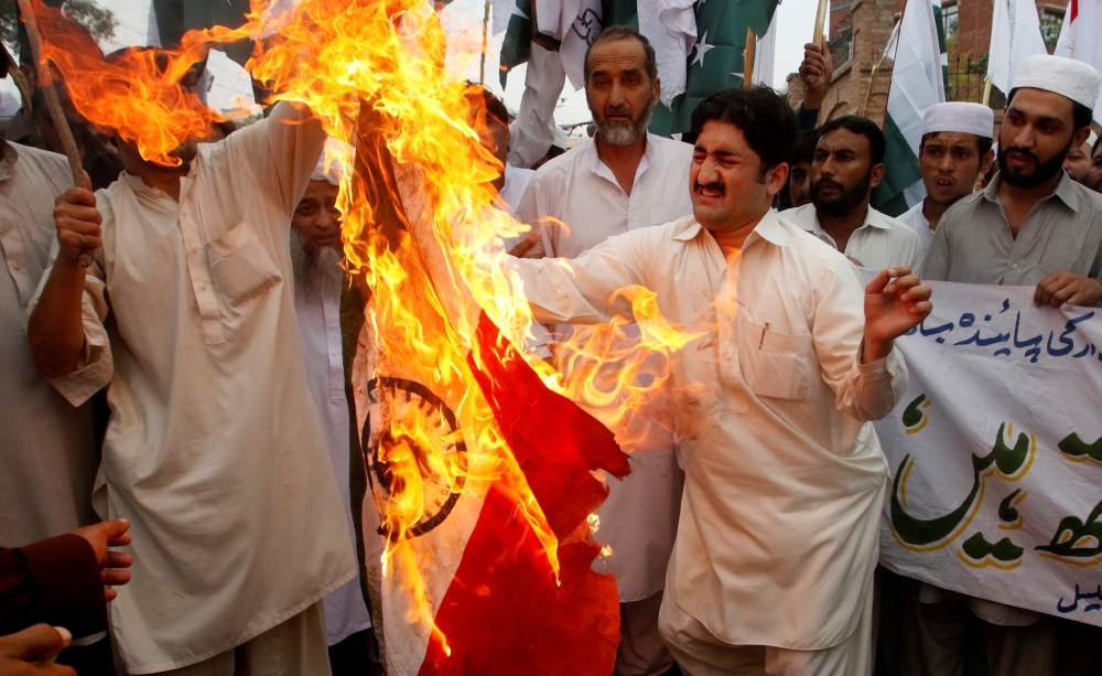 巴基斯坦民眾燒毀印度國旗，抗議近期發生於喀什米爾的衝突。（湯森路透）
