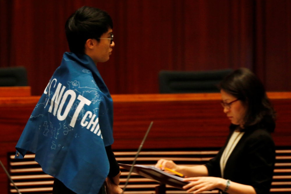 香港立法會議員宣誓儀式上，本土派議員披上「香港不是中國」旗幟。（湯森路透）