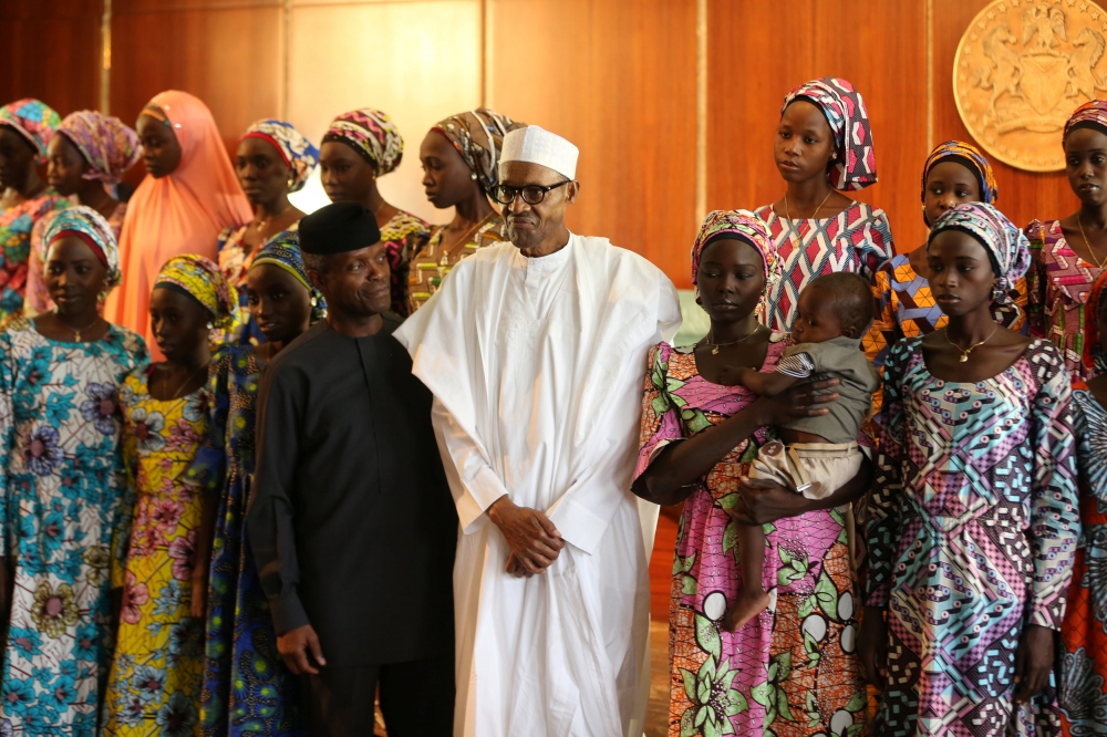 獲釋的21名奇波克鎮（Chibok）女學生，圖（中）為奈國總統布哈里（Muhammadu Buhari）與身旁的副總統奧辛巴喬（Yemi Osinbajo）。（湯森路透）
