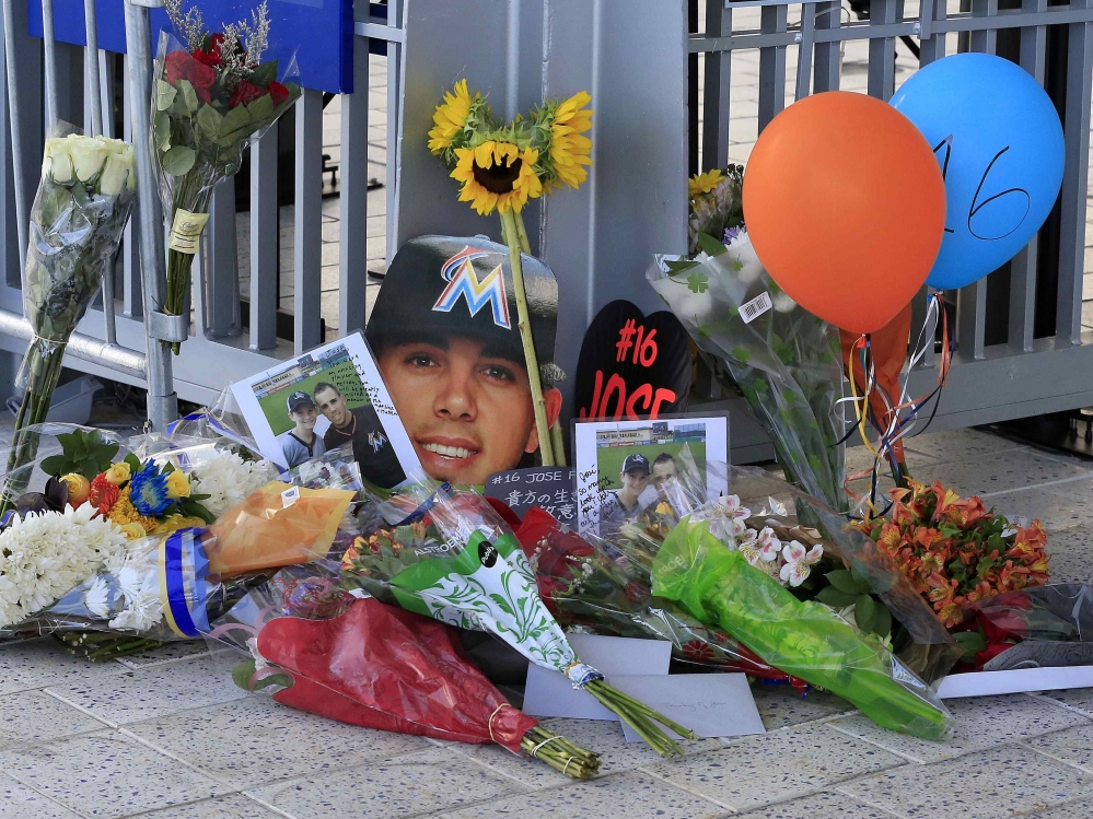 球迷在馬林魚棒球場（Marlins Park）場外擺放花束和照片紀念費南德茲。（湯森路透）