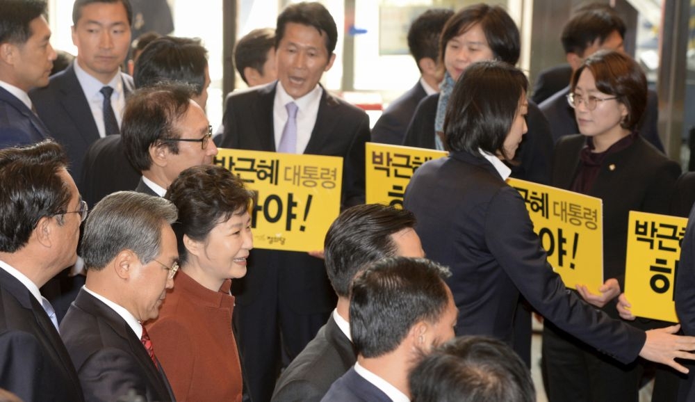 身陷閨密干政醜聞的南韓總統朴槿惠，8日走過抗議人群面前。（湯森路透）