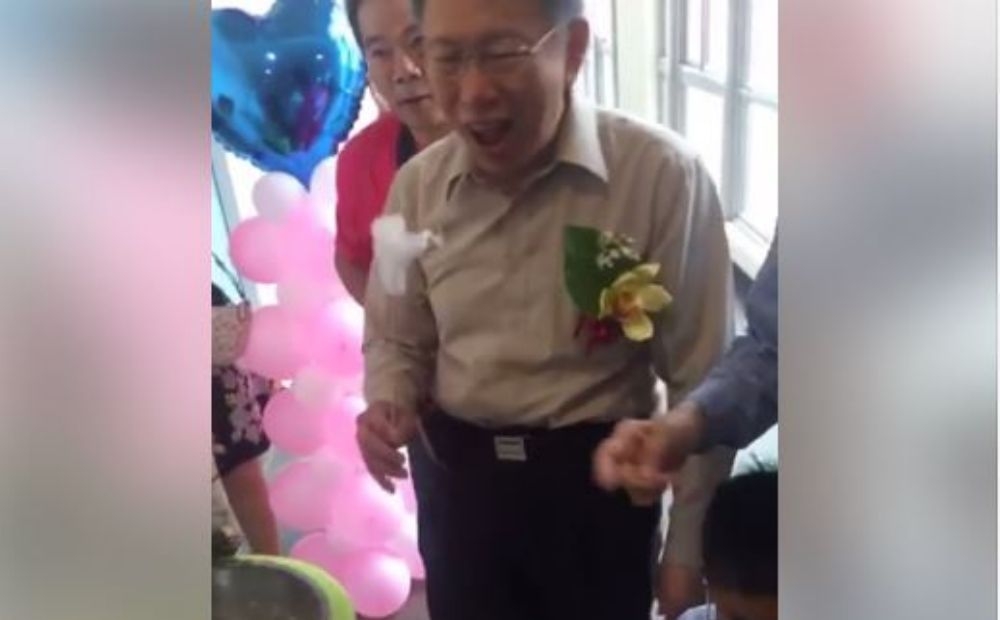 台北市長柯文哲出席北市府聯合婚禮，途中被棉花糖機吸引，當場做起棉花糖還吐舌咧嘴「一口吞下」。（翻攝自柯文哲臉書）