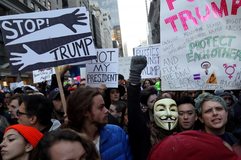 12日紐約第五大道擠滿參加「反川普」抗議遊行的民眾。（湯森路透）