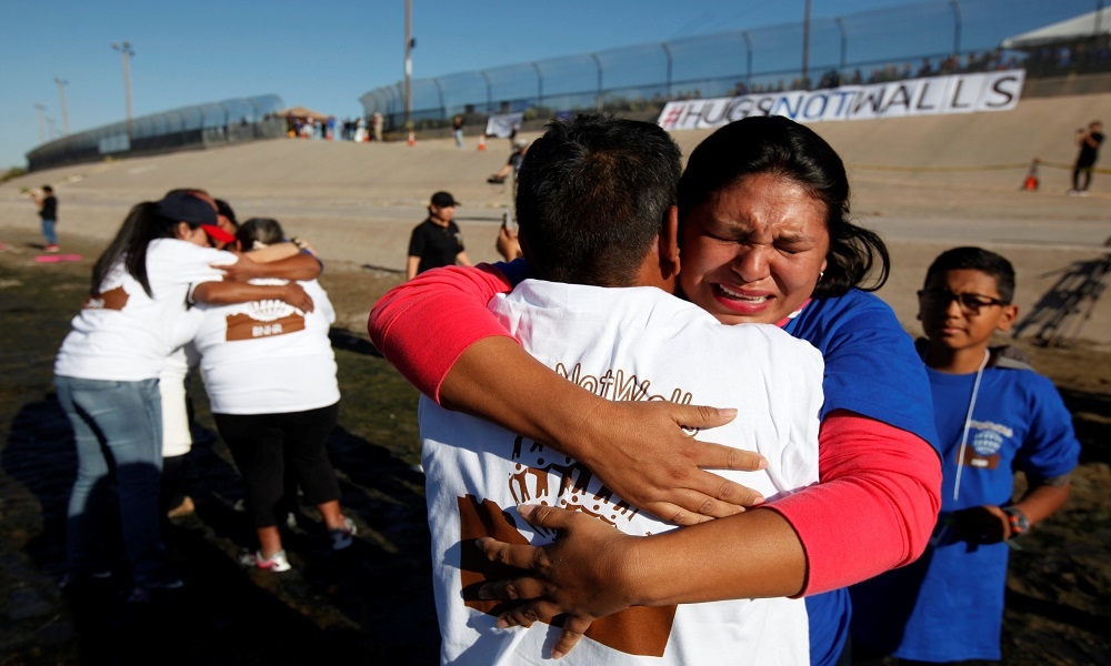 被逐出境的墨西哥人與在美國的家人於美墨邊境布拉沃河短暫會面，相擁而泣。（湯森路透）
