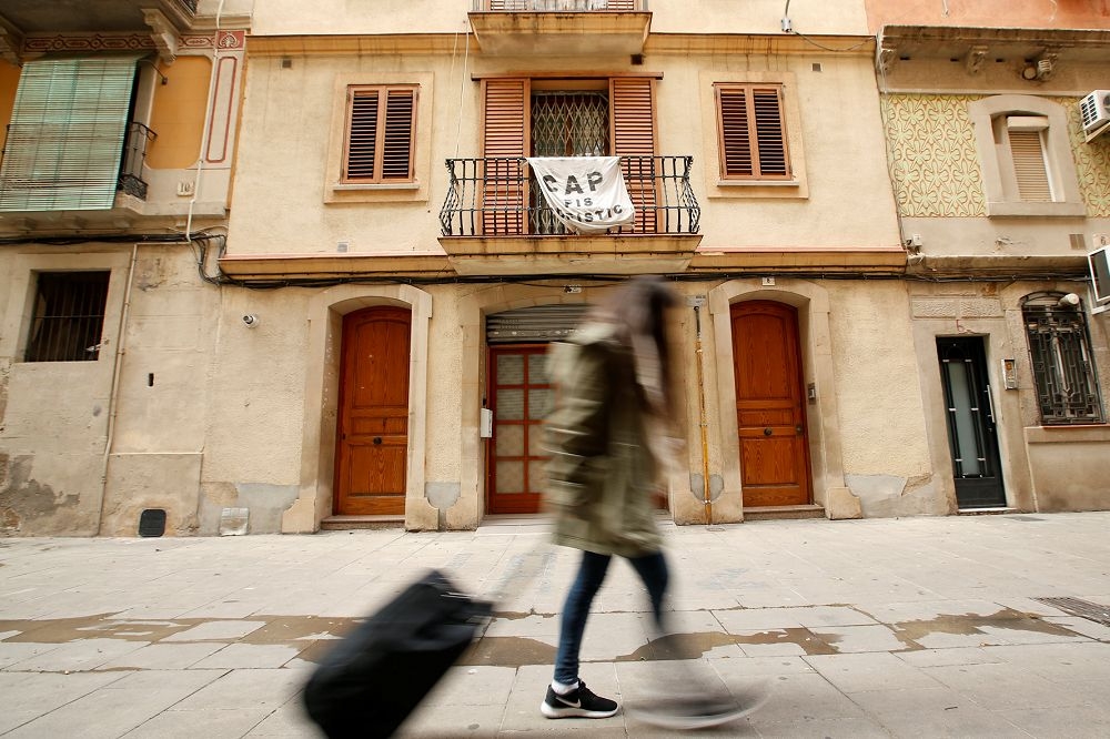 西班牙一大樓住戶在陽台掛上布條，反對鄰居透過Airbnb將他們居住的公寓作為短期日租用。（湯森路透）