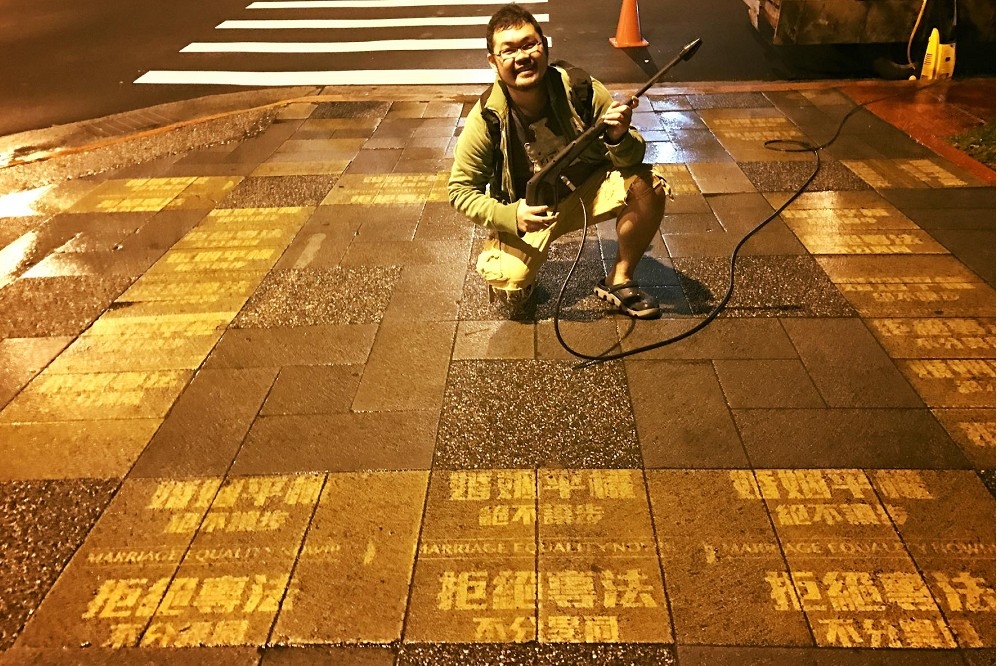 挺同網路名人劉宇，跑到台北多個景點，使用高壓水柱在人行道地板噴上「拒絕專法、不分異同」等字樣，誓言對抗花大錢買廣告的宗教團體。（翻攝自劉宇臉書）