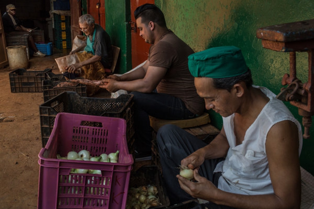 哈瓦那市中心的一個菜市場裡，工人在清理蔬菜。  （紐約時報）