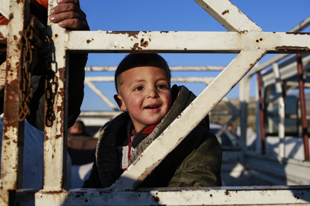 一位敘利亞孩童準備與家人一同入境土耳其。（美聯社）