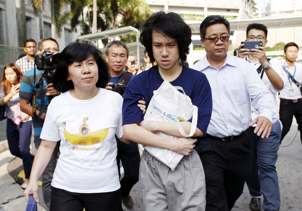 余澎杉（藍衣者）2015年7月在雙親的陪同下，步出新加坡州立監獄。（湯森路透）
