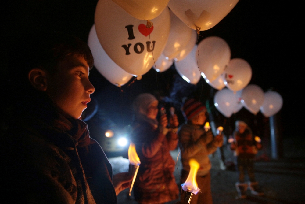 敘利亞兒童在停火首日晚間放出寫著「我愛你」（I love you）字樣的氣球，標誌2016年戰亂的終結。（湯森路透）