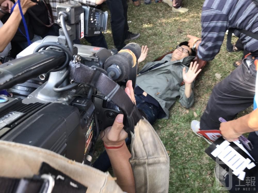 年金改革座談會台中場，會前場外抗議民眾爆發推擠衝突，有一名男子被倒在地。（攝影：盧禮賓）