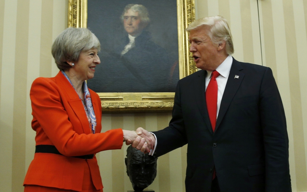 英國首相梅伊（左）與川普握手。（湯森路透）