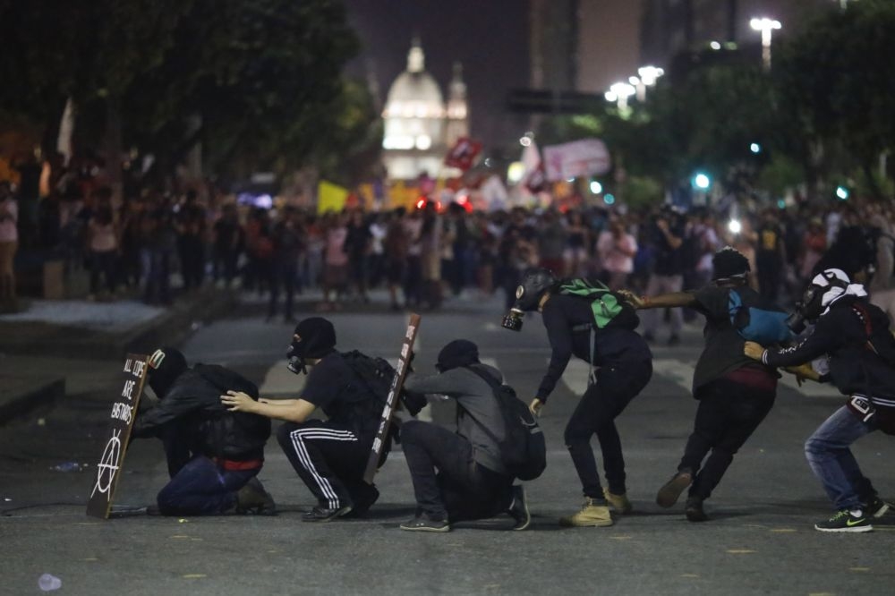 巴西里約熱內盧的年金改革抗議民眾頭戴防毒面具和警方對峙。  （美聯社）