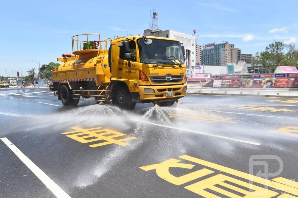 近日熱浪不斷，北市前日創下38.5度的今年最高溫，故北市府派出灑水車替馬路「降溫」。但亟需用水的關頭，台水9日表示，將向經濟部提出水價調漲規劃。（攝影：葉信菉）