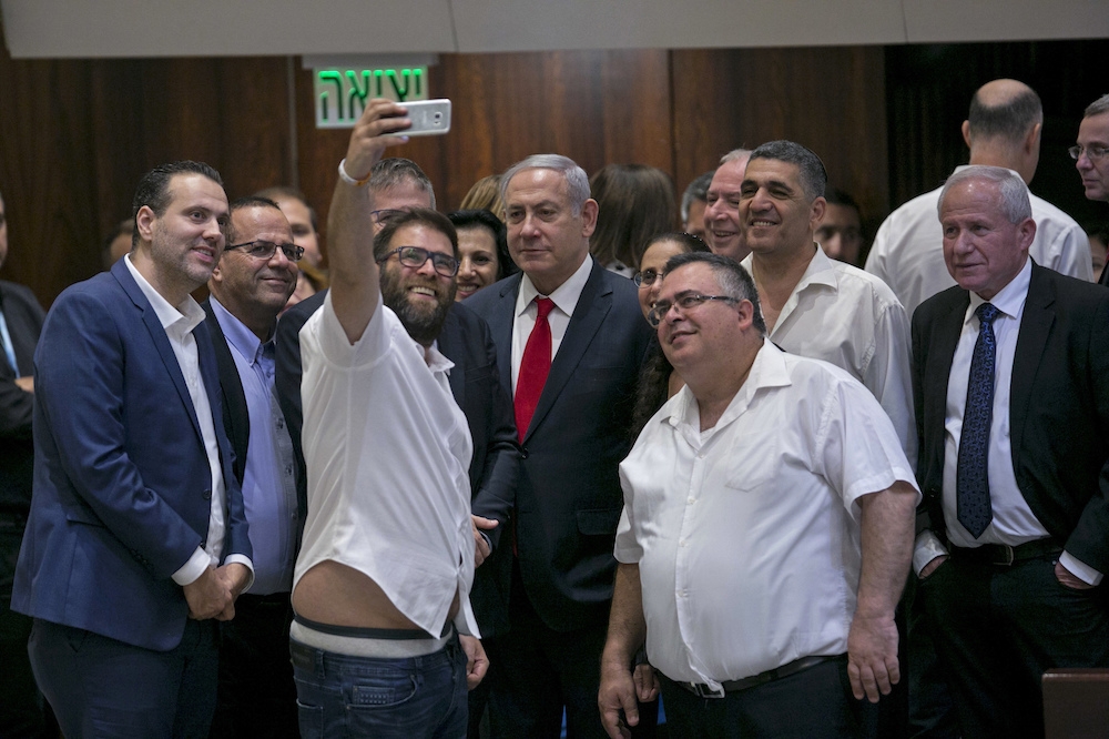 以色列國會19日通過《猶太民族國家法》後，右翼執政黨與總理納坦雅胡自拍紀念。（美聯社） 