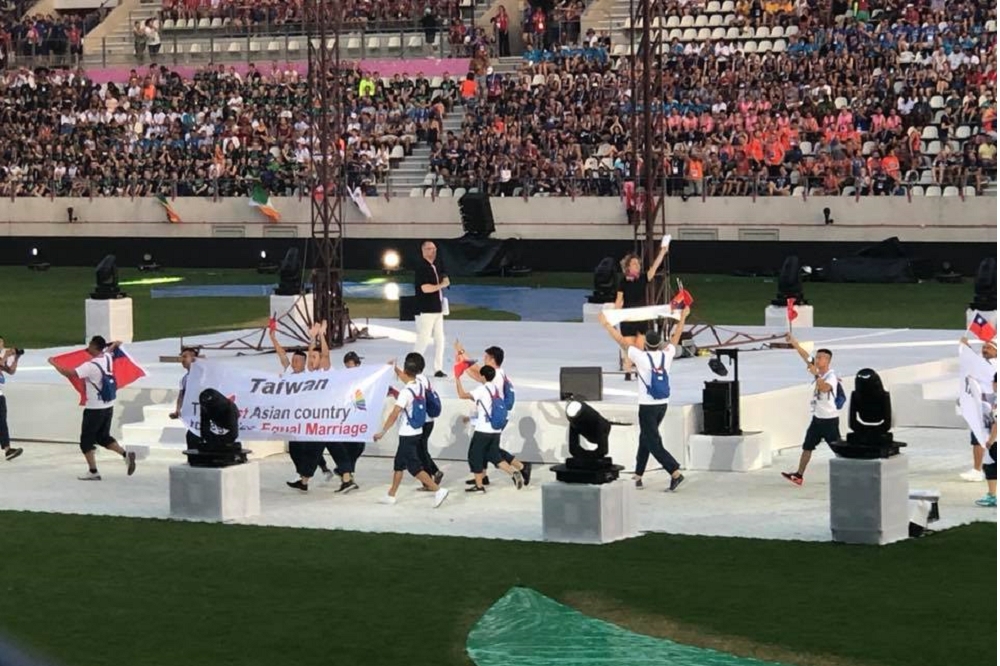 第10屆國際同志運動會開幕式，我代表團帶著國旗出場，還拿著長白布用英文寫著「台灣，第一個婚姻平權合法化的亞洲國家」。（圖片取自Sean Howell臉書）
