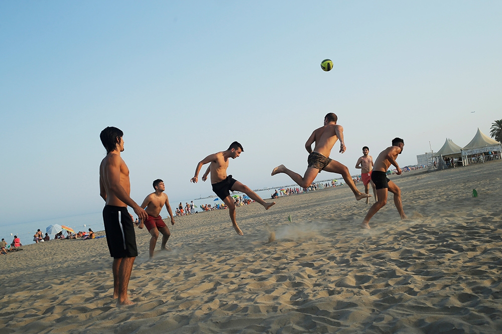 不少西班牙人在高溫下來到沙灘玩樂玩水。（湯森路透）