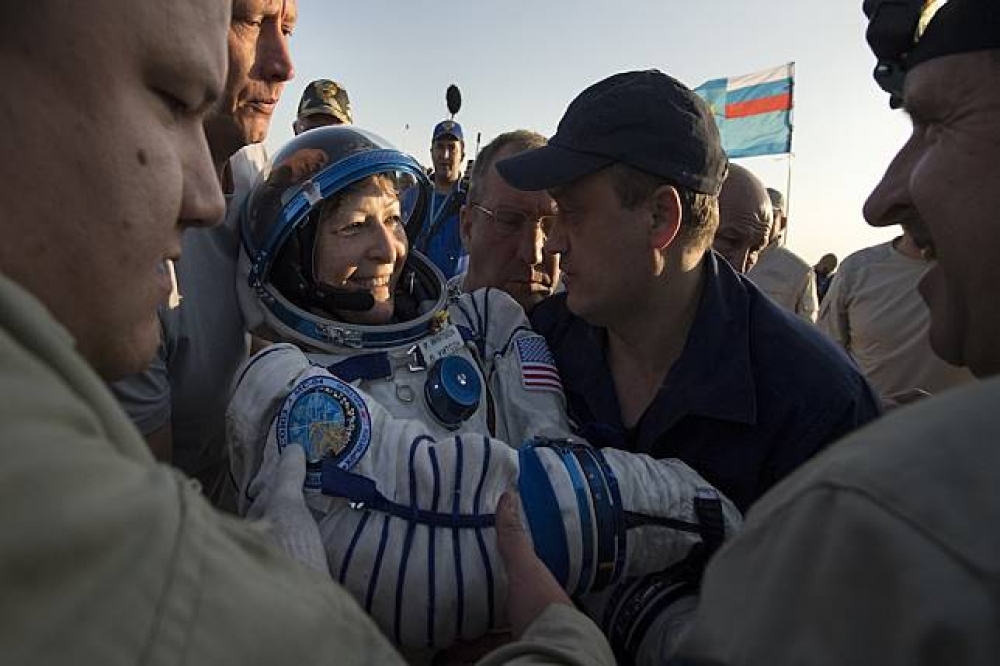 美國太空人惠特森抵達地表後由人攙扶離開現場。（美聯社）