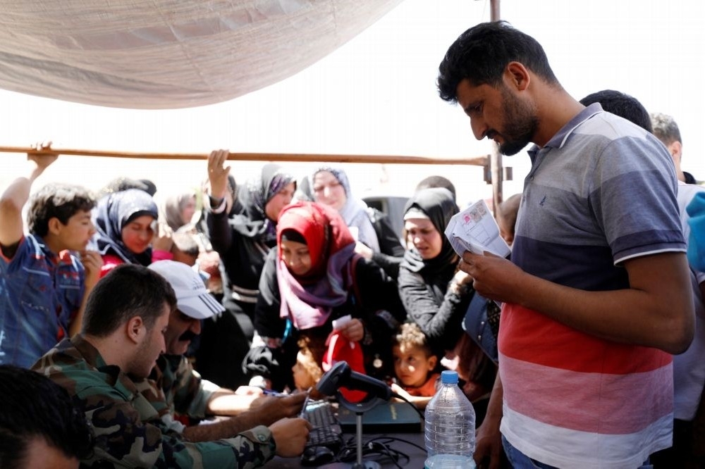敘利亞難民在救援組織進行身分登記。（湯森路透）