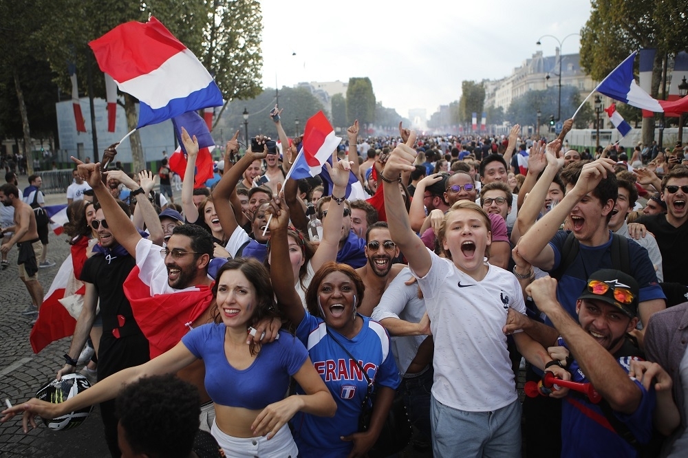 法國民眾高興揮舞國旗慶祝勝利。（美聯社）