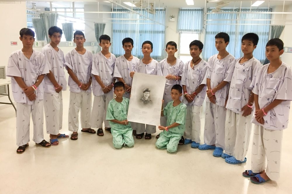 獲救的12名泰國足球隊員與教練（左一）因恢復狀況良好，18日獲准提前出院。（湯森路透）