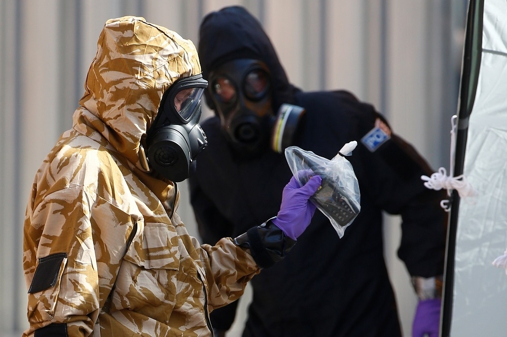 穿著防護衣的鑑識調查人員於英國埃姆斯伯里調查神經毒劑案。（湯森路透）