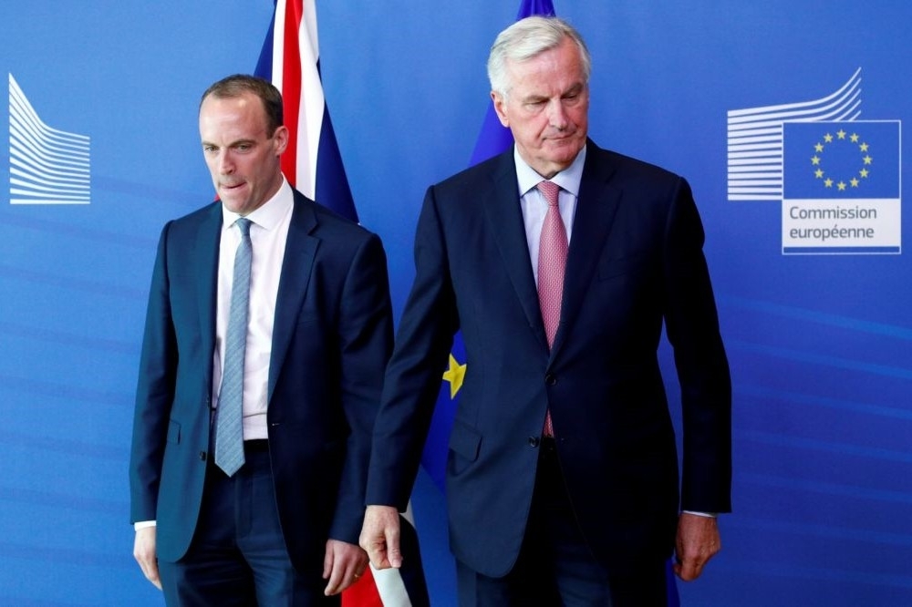 新任英國脫歐大臣拉布（右）19日與歐盟脫歐首席談判代表巴尼耶會面協商。（湯森路透）