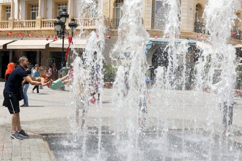 突尼西亞人民藉由噴水池消暑。（湯森路透）