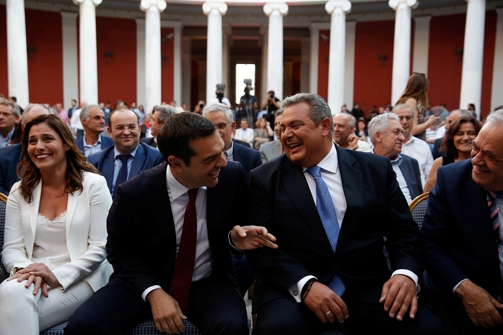 希臘總理齊普拉斯（中），與希臘國防部長帕諾斯（右）在演說完後有說有笑，象徵債務減免協議的成功。（湯森路透）