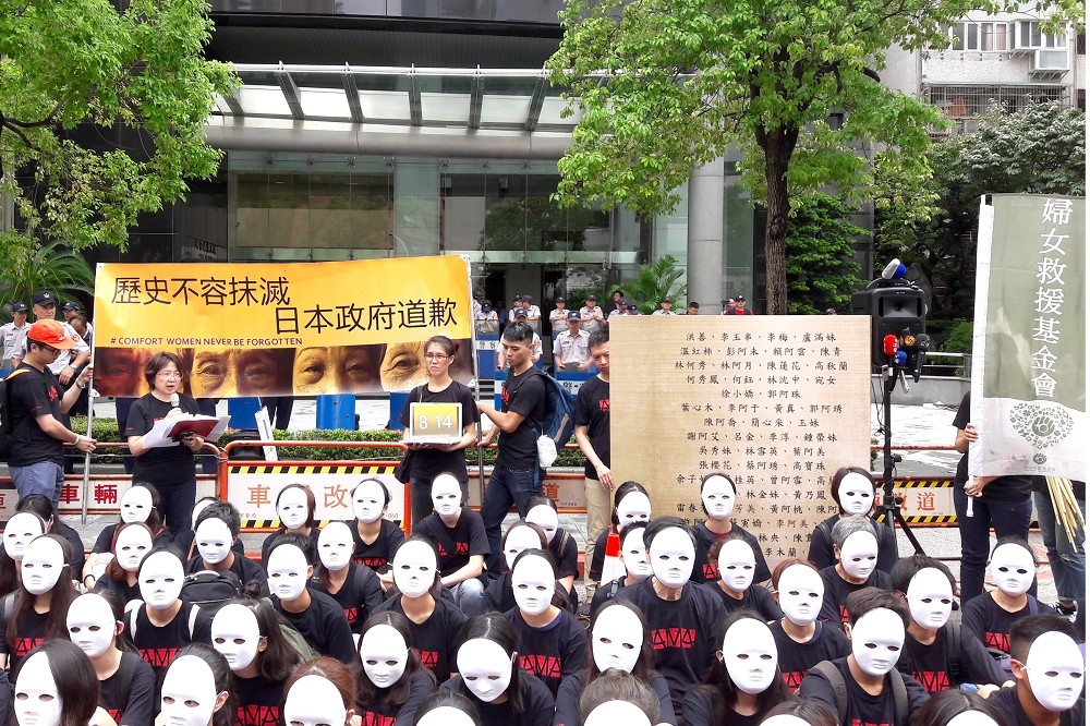 59位戴白面具民眾，聚集在日本交流協會前，代表慰安婦阿嬤靜坐抗議。(婦女救援基金會提供)