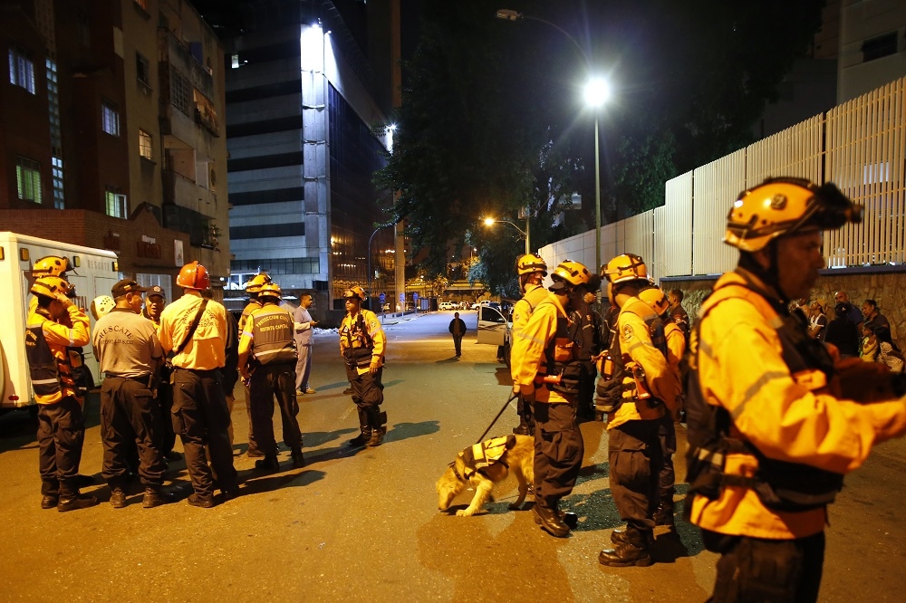 委內瑞拉發生規模7.3強震，首都卡拉斯卡警消人員協助疏散民眾。（湯森路透）