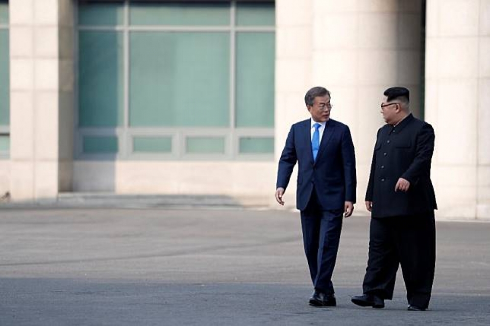 北韓領導人金正恩（右）27日與南韓總統文在寅於板門店舉行歷史會談。（湯森路透）