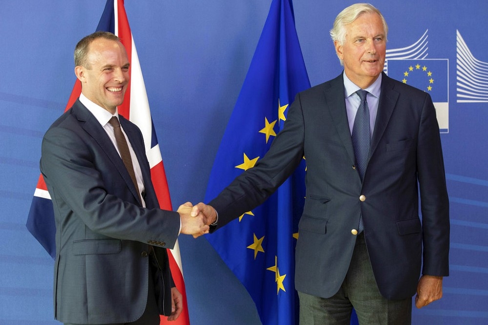左為英國脫離歐洲聯盟事務大臣藍韜文（Dominic Raab），右為歐盟首席談判官巴尼爾（Michel Barnier），8月21日在歐盟總部握手致意。（美聯社）
