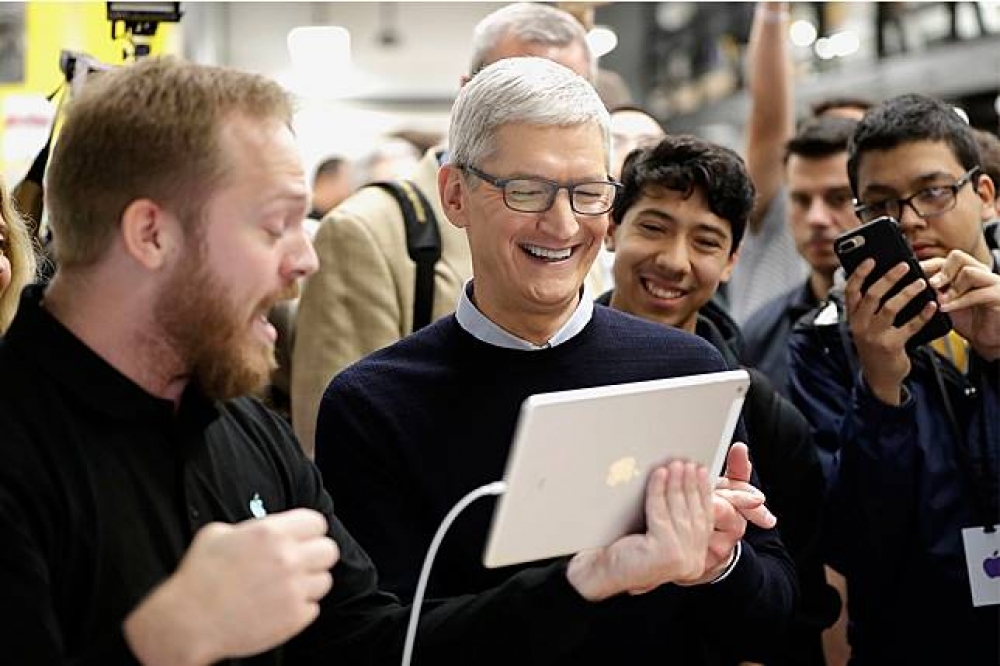 蘋果執行長庫克27日於芝加哥發表會現場體驗新版iPad。（AP）