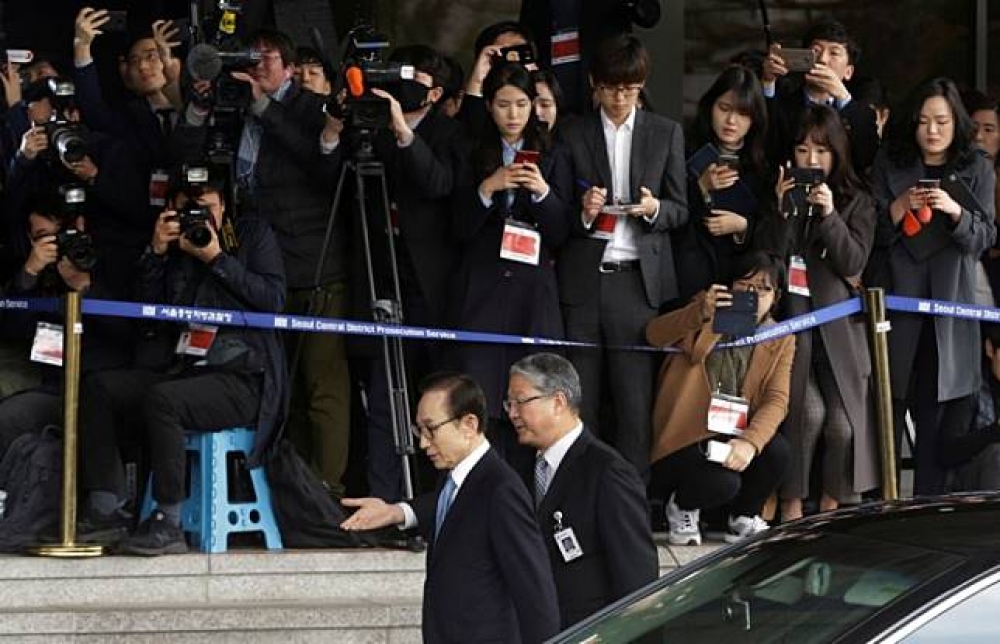 南韓前總統李明博（左）14日接受檢方偵訊。（湯森路透）