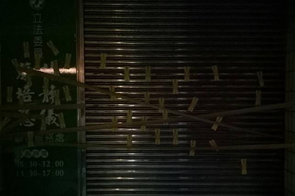 民進黨南投縣黨部遭貼「過勞退散」等抗議過勞的符咒。（圖片取自臉書DPP in Nantou 民進黨南投縣黨部）