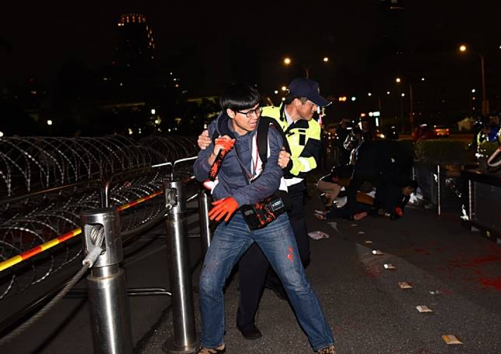 大觀自救會抗議成員在31日晚上6時許到總統府前潑紅漆。（攝影：李昆翰）