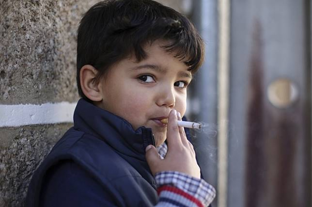 葡萄牙北部的瓦萊-迪薩爾蓋魯（Vale do Salgueiro）地區慶祝主顯節時，一名6歲孩童正在吸菸。（美聯社）