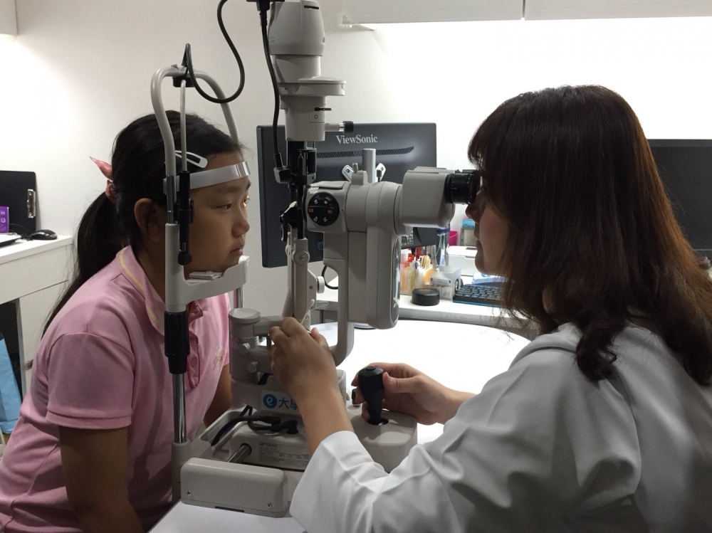 莊醫師為陳妹妹術檢視力狀況。（圖片來源：大學眼科）