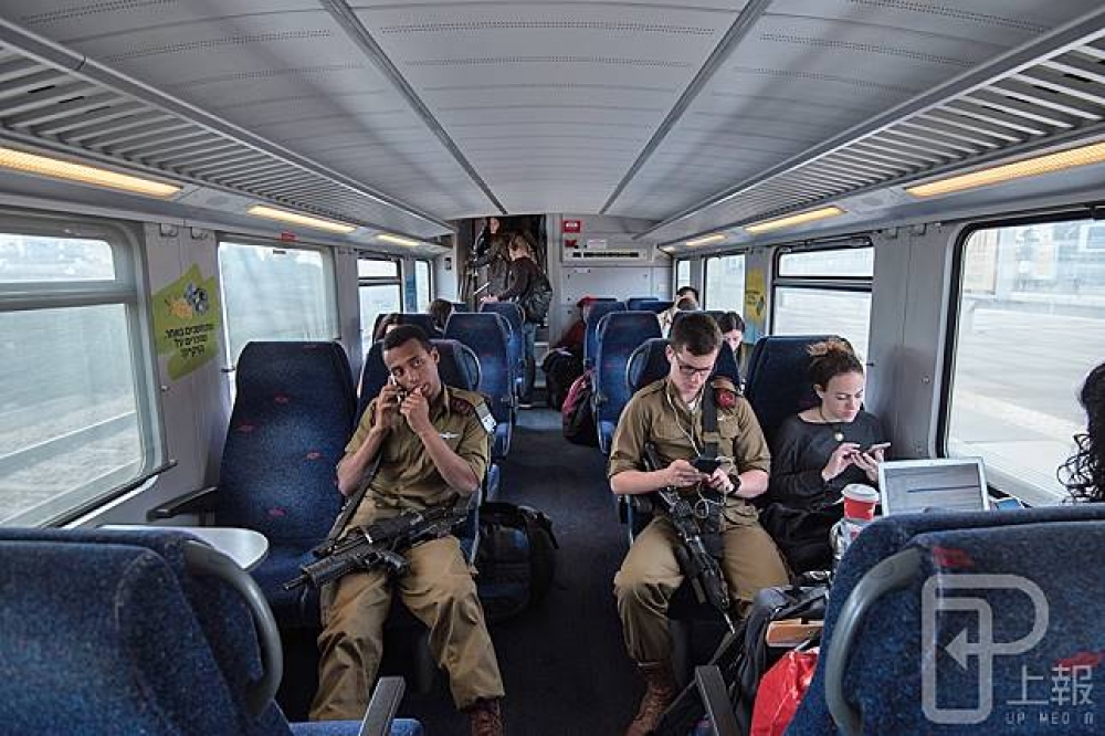 火車上坐滿了背著大背包的以色列軍人，長槍就擱在腿上。（攝影：李昆翰）