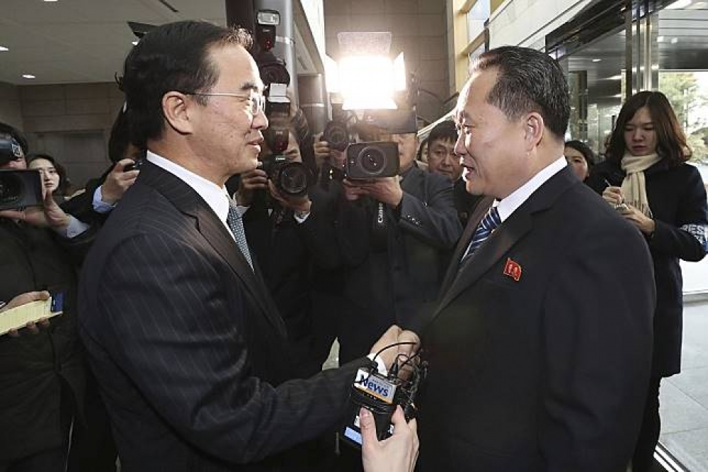 韓國統一部長趙明均（左）與朝鮮祖國和平統一委員會委員長李善權（右）在會談開始前握手致意。（美聯社）