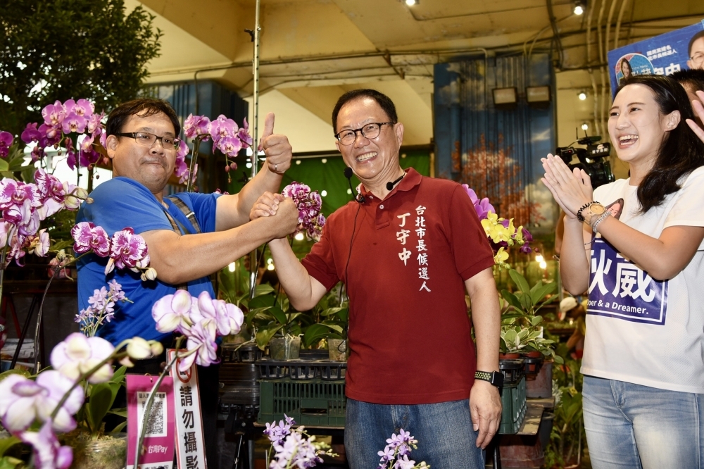 國民黨台北市長參選人丁守中23日前往建國花市拜票，沿路和花卉攤販握手致意。（攝影：張文玠）