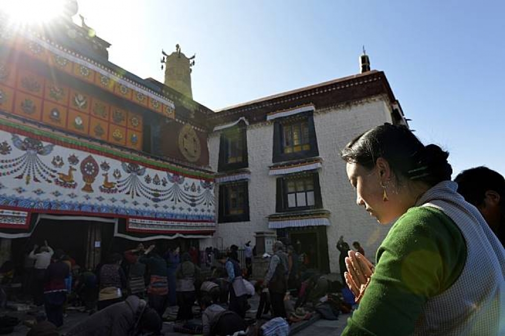 藏族信教民衆在拉薩大昭寺前虔誠朝佛。（中新社）