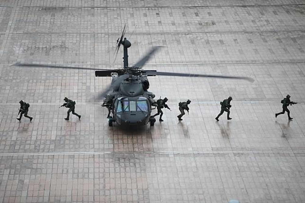 國防部12日於博愛營區進行直升機落地預演任務。圖為陸軍UH-60M黑鷹直升機搭載特戰小組降落目標區。（國防部提供）