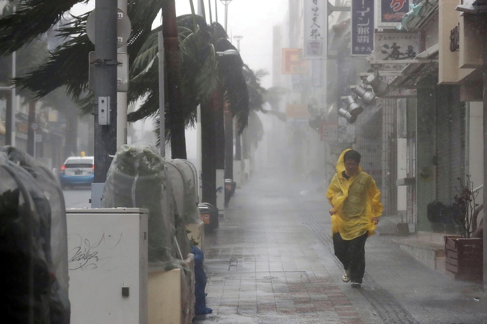潭美颱風在沖繩地區造成災害，強風大雨讓人寸步難行。（湯森路透）