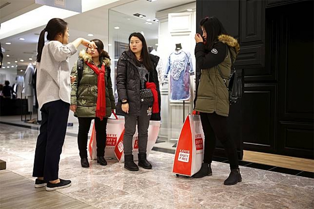 中國觀光客赴南韓樂天百貨採購。（湯森路透）